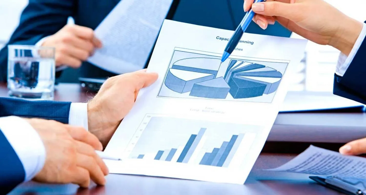 3 hands shown in which is reading accounting report other 2 is discussing a diagram graph